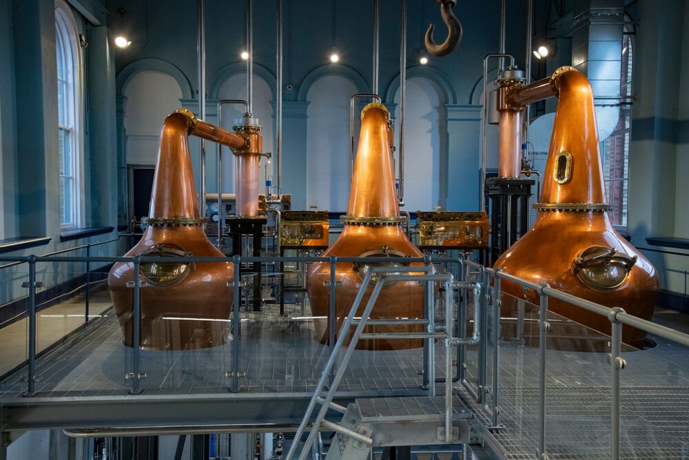 three copper coloured whiskey vessels